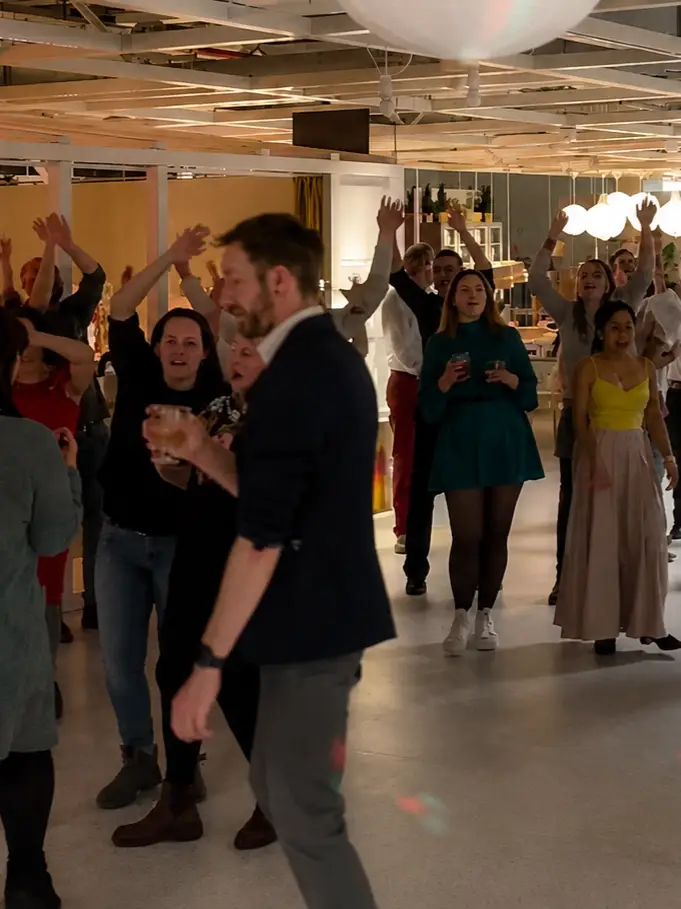 feiernde Mitarbeiter in der Ikea Nürnberg mit Orange Partyband